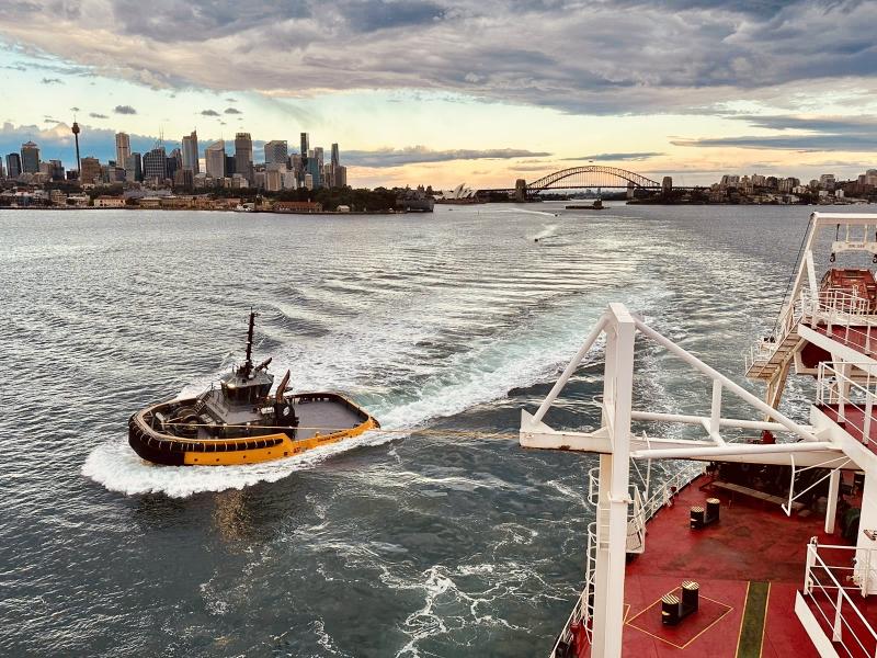 Engage Marine tug navigating Sydney Harbour with the iconic city skyline and Harbour Bridge in the background at sunset.